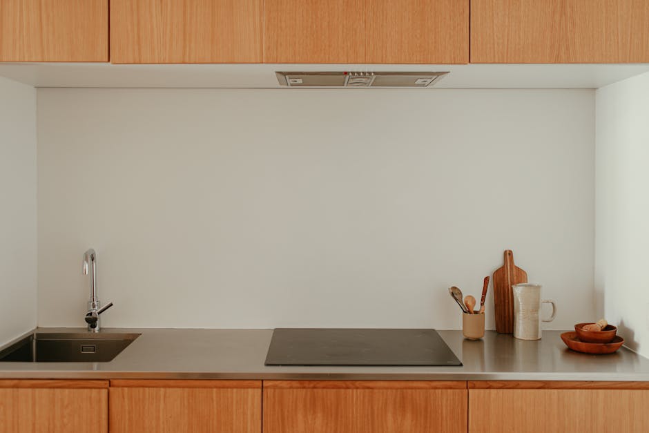 A sleek, minimalist kitchen with wooden cabinets and stainless steel surfaces; perfect for contemporary homes.
